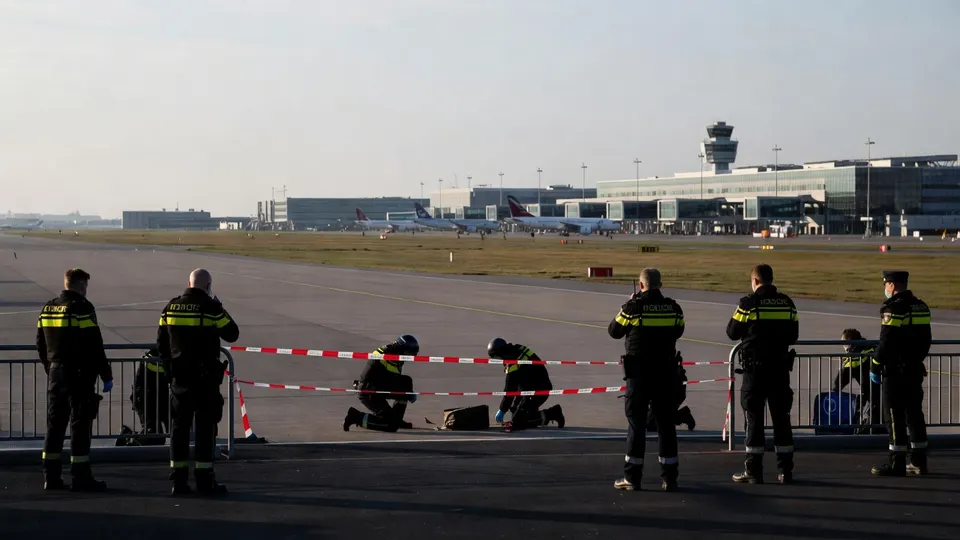 Hulpdiensten onderzoeken een afgezet gebied naast een landingsbaan van Eindhoven Airport