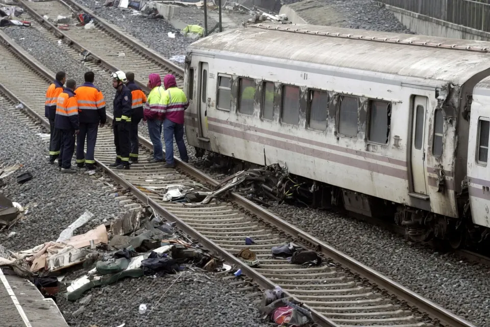 Hulpverleners bekijken een ontspoorde trein na een spoorwegongeval in Spanje