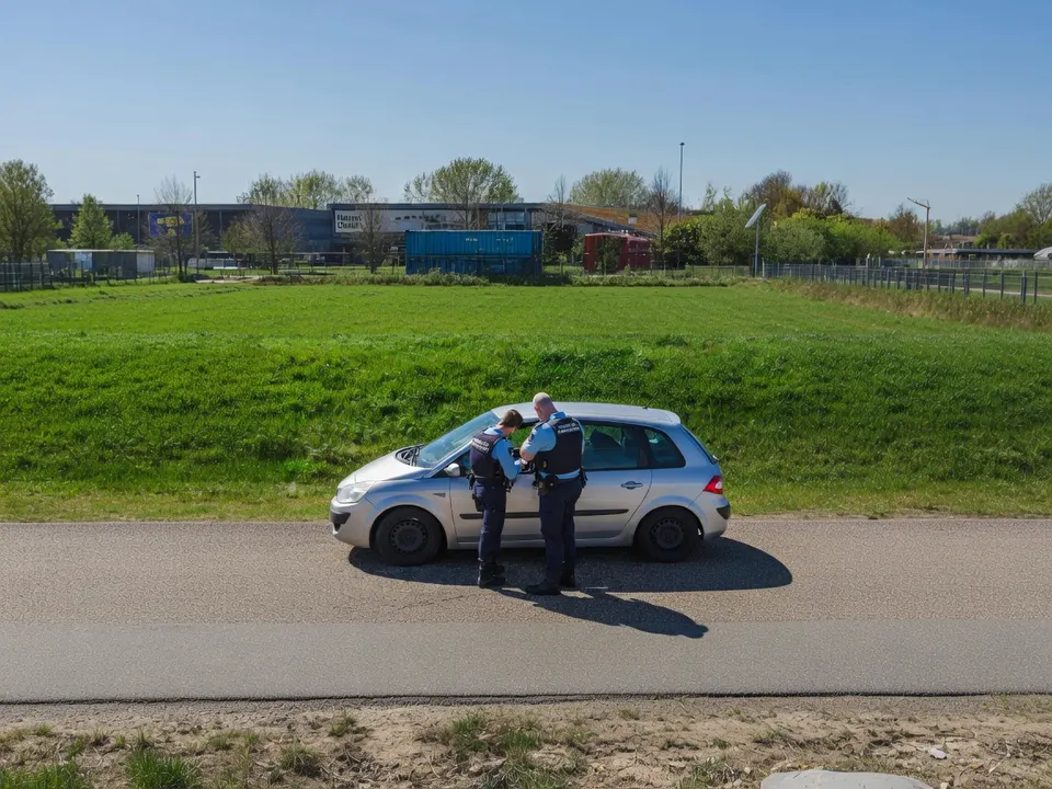 Marechausseemedewerkers controleren een automobilist bij de grens