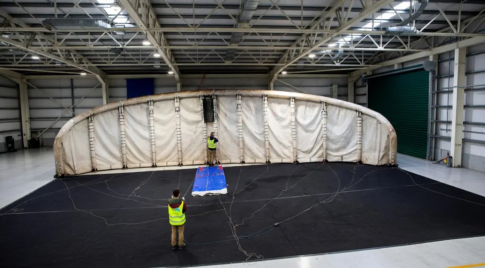 Een grote vlieger van windenergiebedrijf KitePower wordt getest in een bedrijfshal