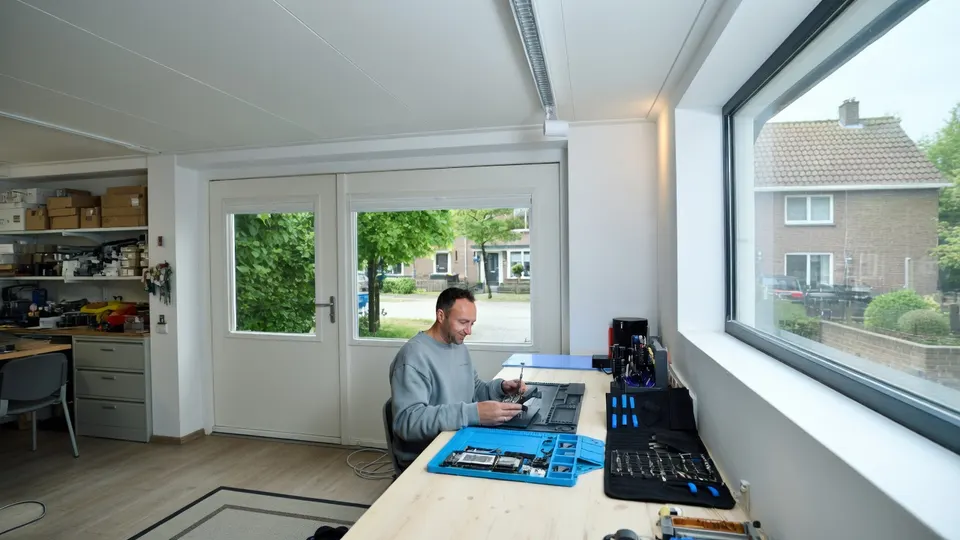 Een reparateur werkt aan een smartphone met speciaal gereedschap