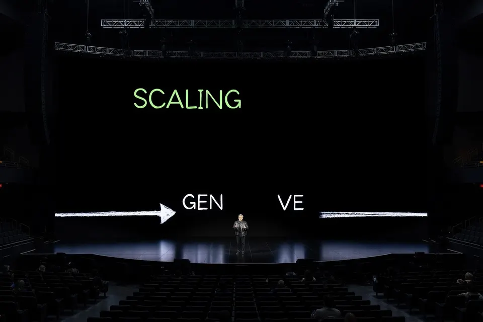 Een spreker staat op een podium voor een scherm met de tekst 'SCALING GEN VE'