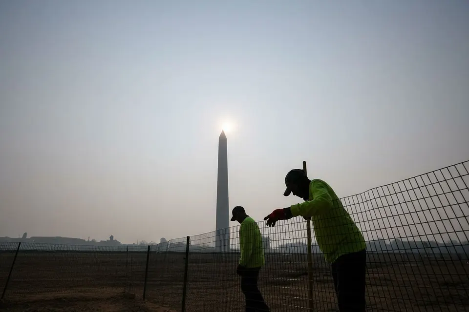 Mensen lopen langs het Washington Monument terwijl rook de lucht in de Amerikaanse hoofdstad vertroebelt