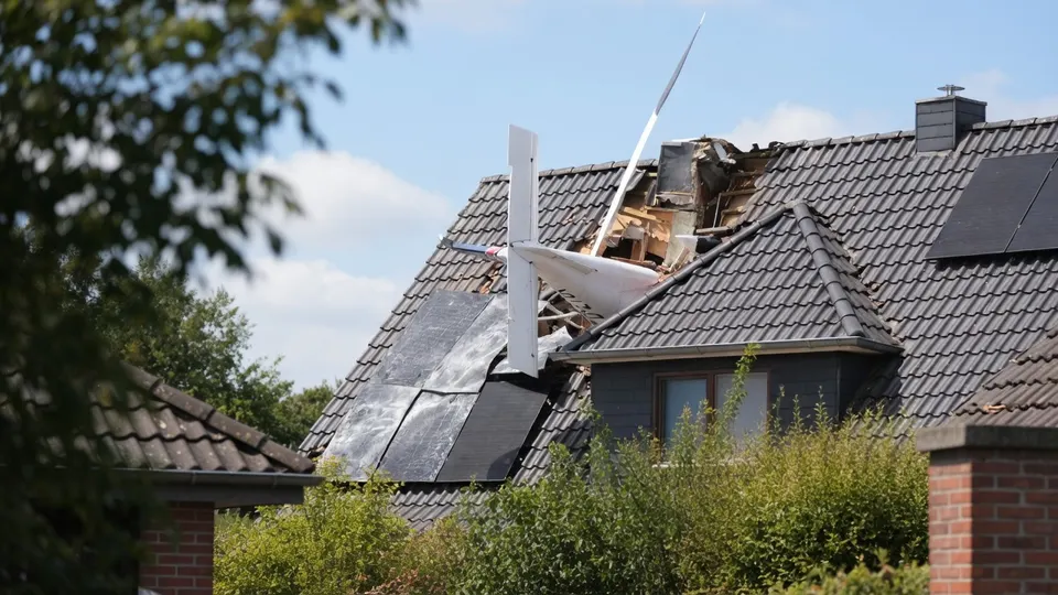 Een vliegtuig ligt na de crash op het dak van een woning in Ganderkesee bij Bremen