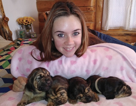 Junior Star Program Karissa smiles with some pups from her recent litter.