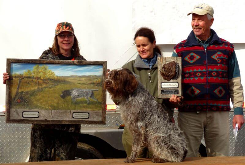 A group of people and a dog posing for a picture.