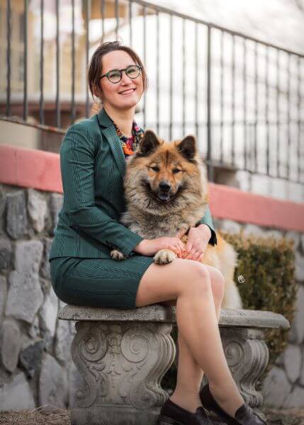 Kelsey Keefe sitting on bench with her Eurasier.