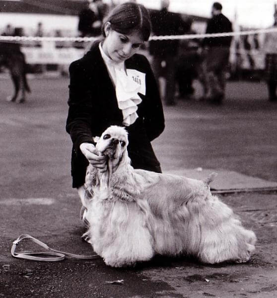 A Black and white picture of a girl petting a dog.