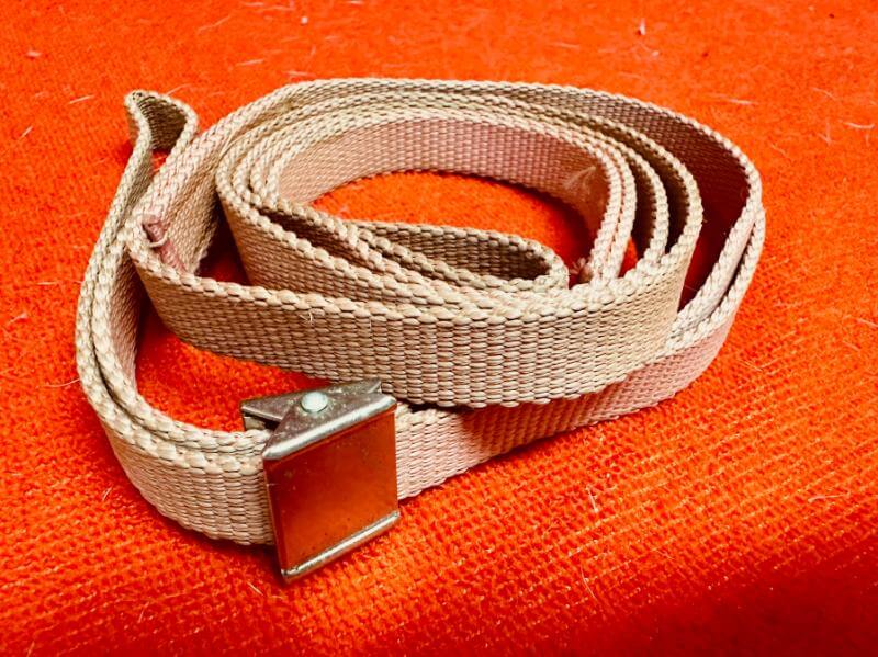 A beige belt with a metal buckle on it.