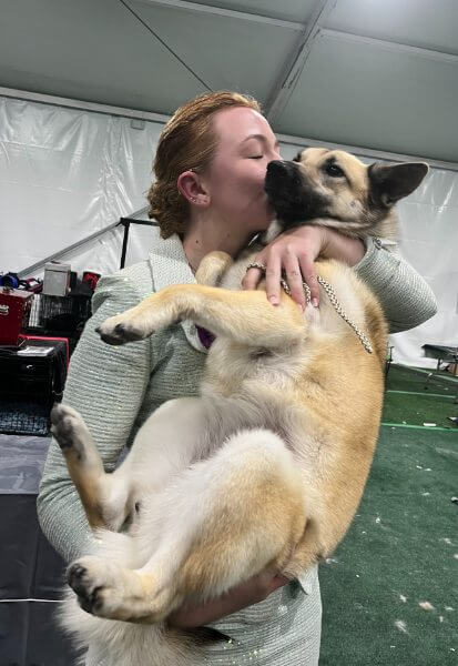 Octavia Stensen holding and kissing her dog.