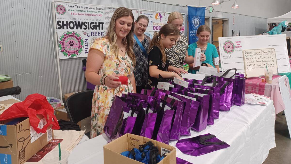 Event Chair and former Junior Roxanne Bashor assists Demery Livingston, Jordyn Seymour, and Katie Sorensen with the Swag Bags as Katie’s mom Missy looks on.