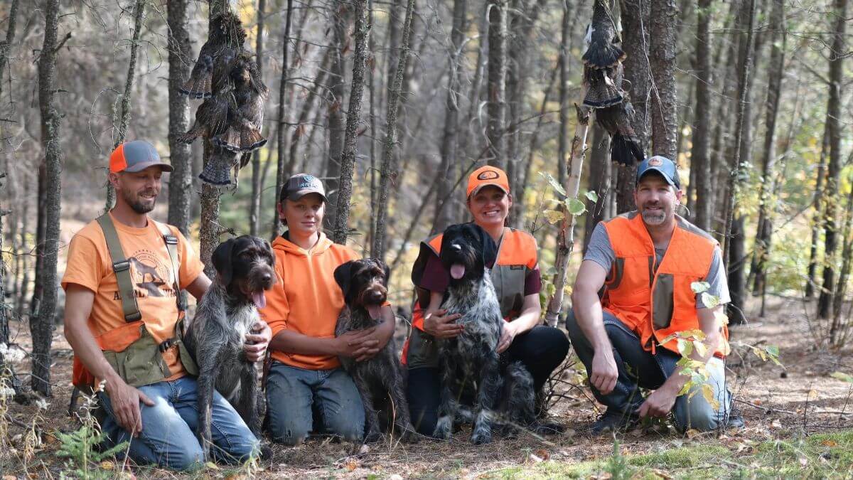 Family with German Wirehaired Pointers in the woods