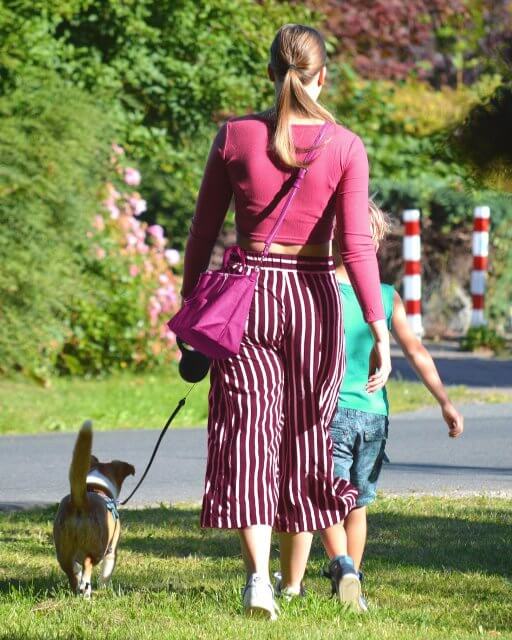 Woman and her child walking their dog, outside in the nature