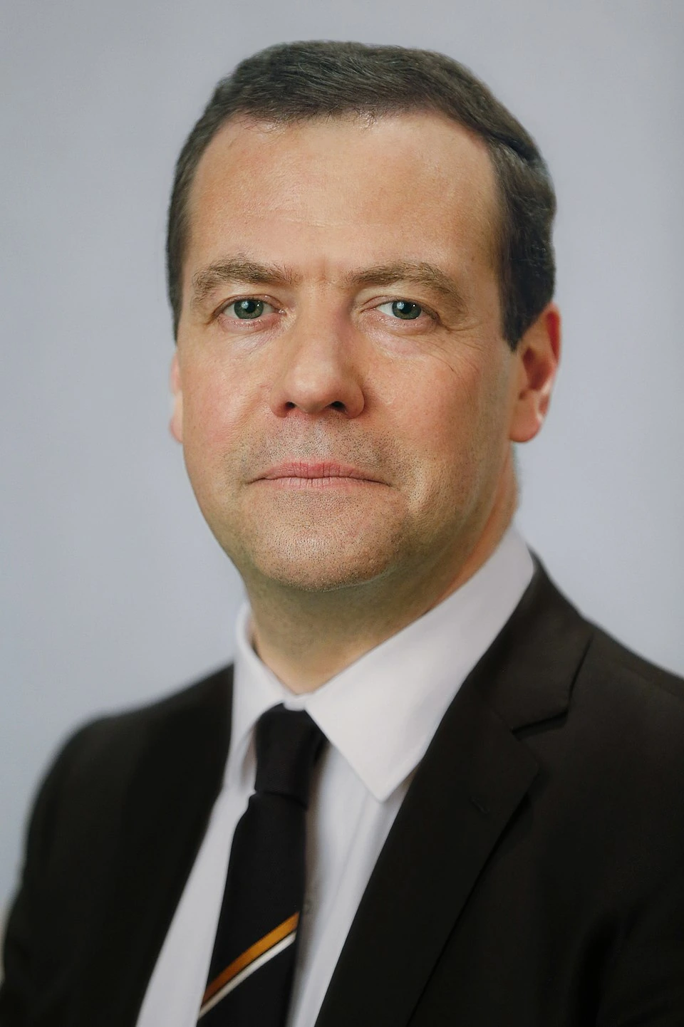Dmitry Medvedev in an official portrait, wearing a dark suit and tie against a plain background
