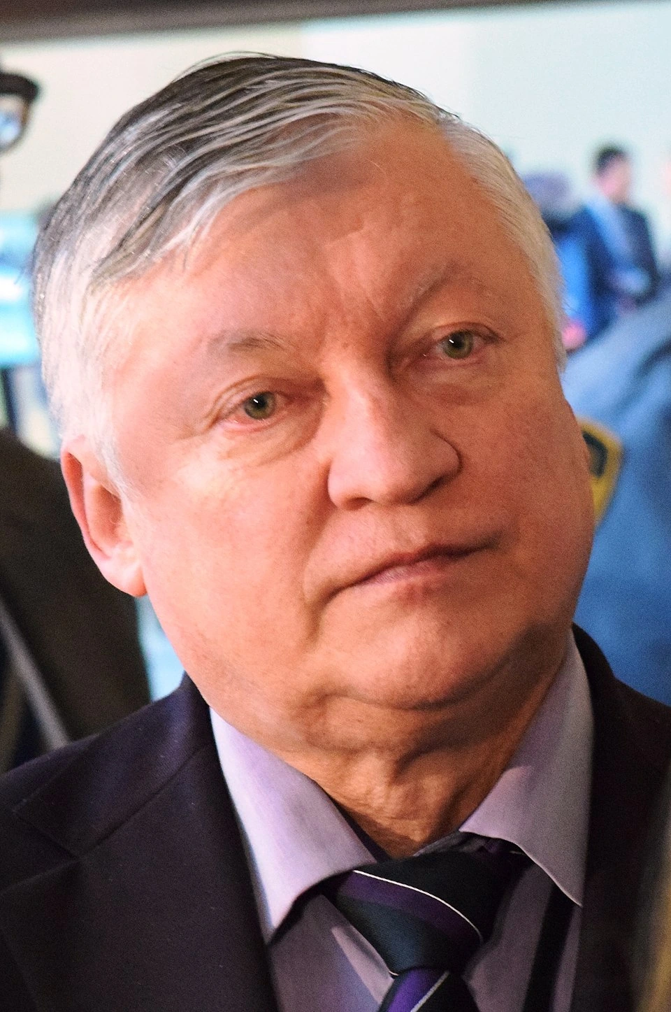 Anatoly Karpov in a close-up portrait at an event, wearing a suit and tie.