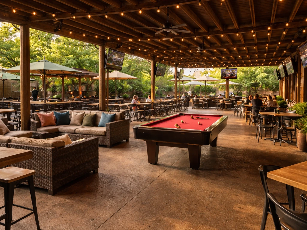Wide shot of a large covered Texas-sized patio with outdoor seating and a pool table.