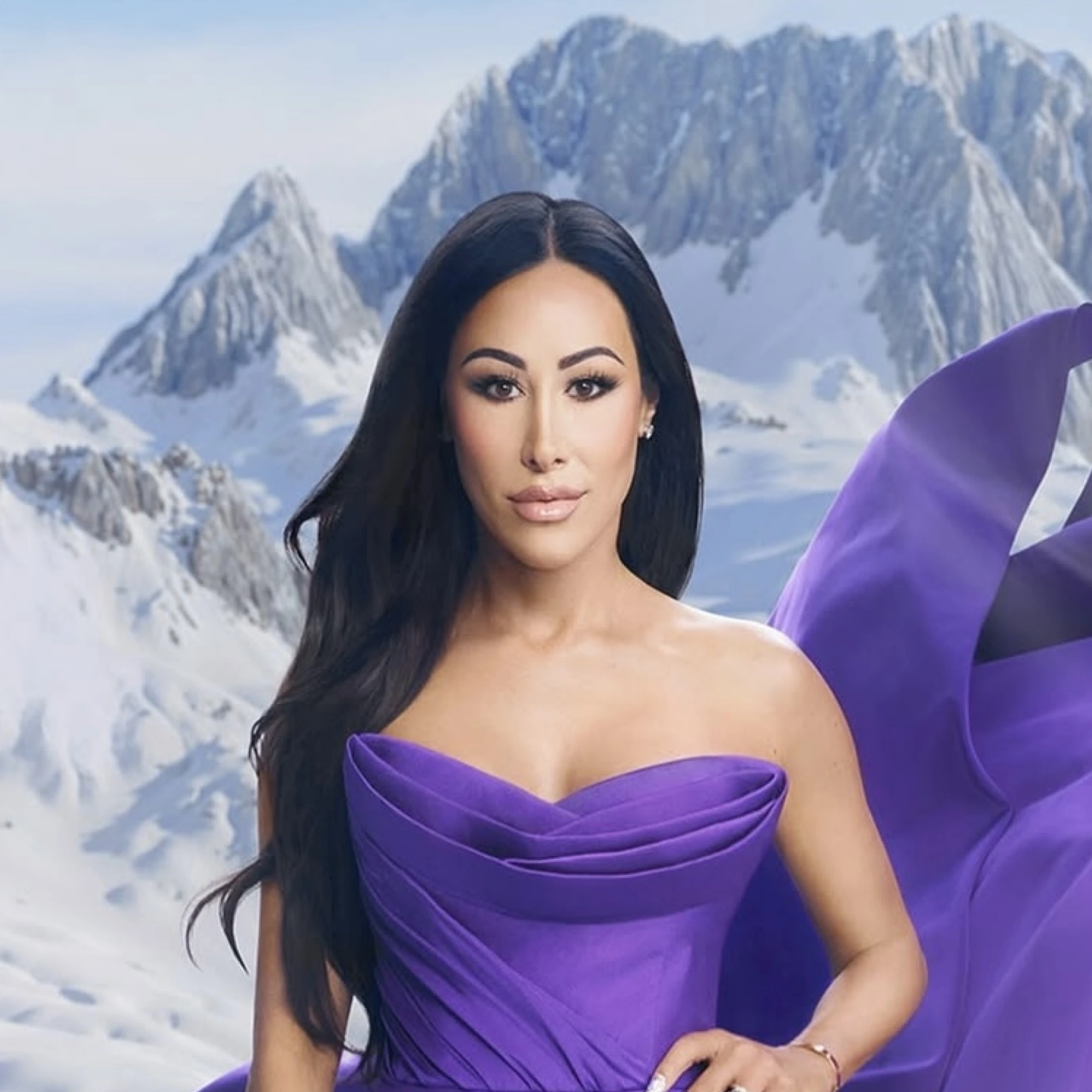Angie Katsanevas posing in a purple strapless dress against a snowy mountain backdrop