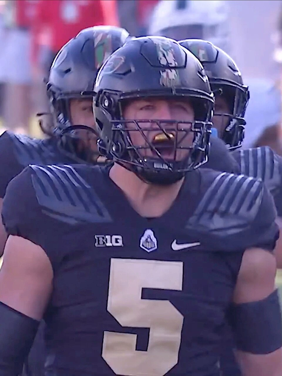 George Karlaftis in a football uniform and helmet during a game, wearing jersey number 5.