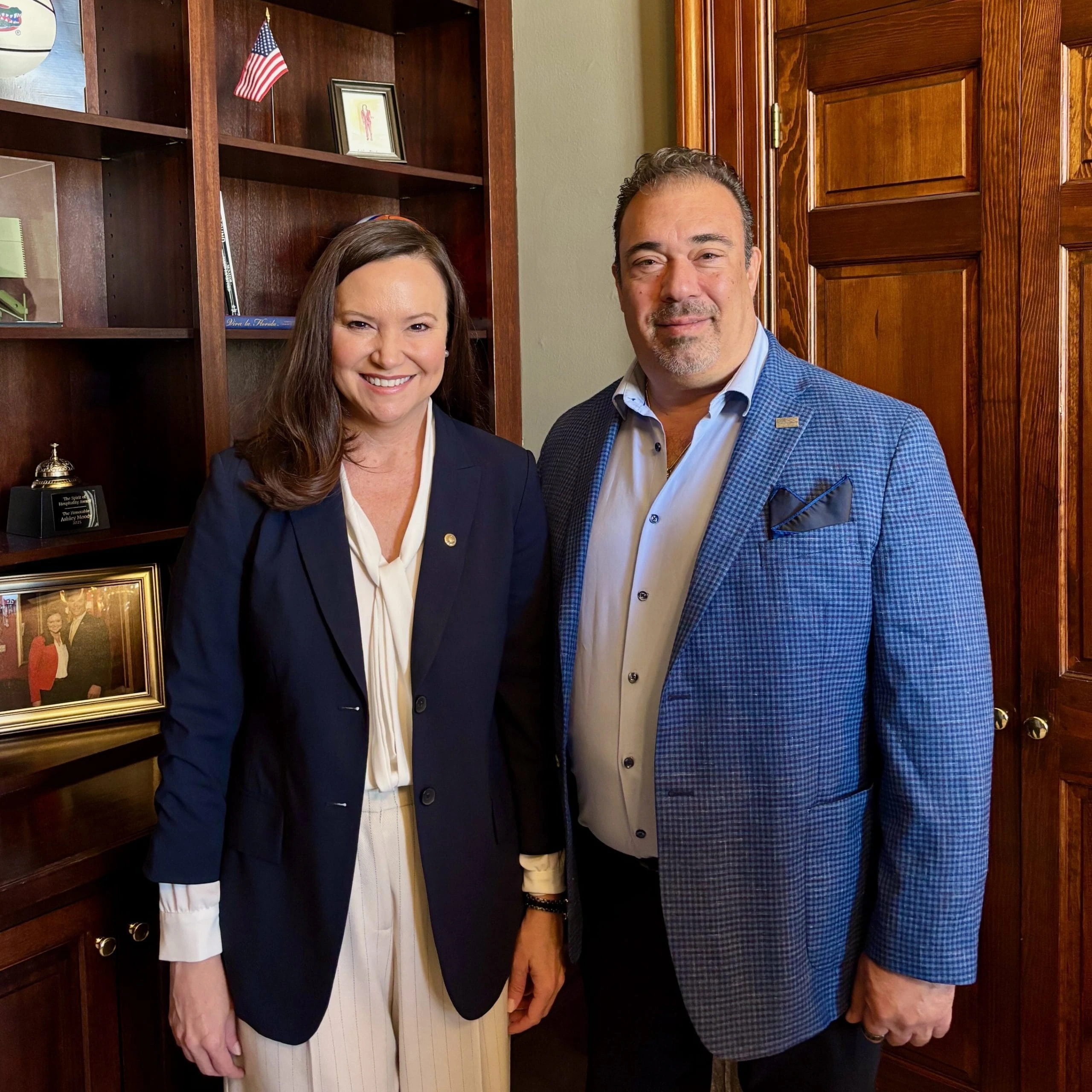 Spero Georgedakis standing beside a woman in an office setting