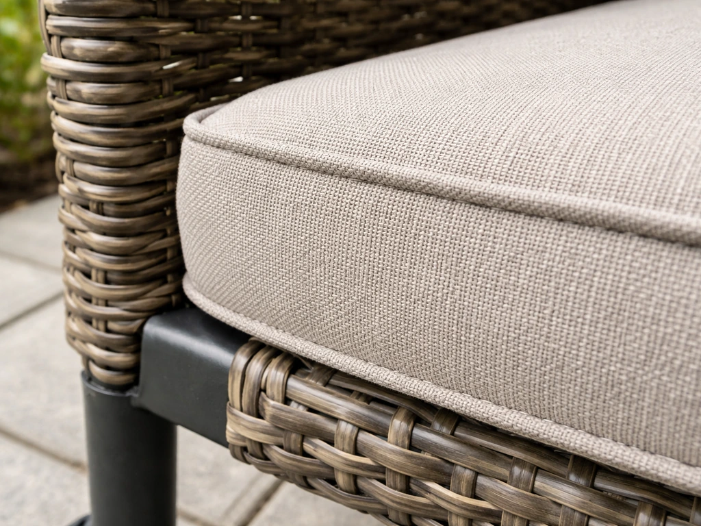 Close-up of PE wicker over a steel frame with a thick outdoor cushion fabric edge.