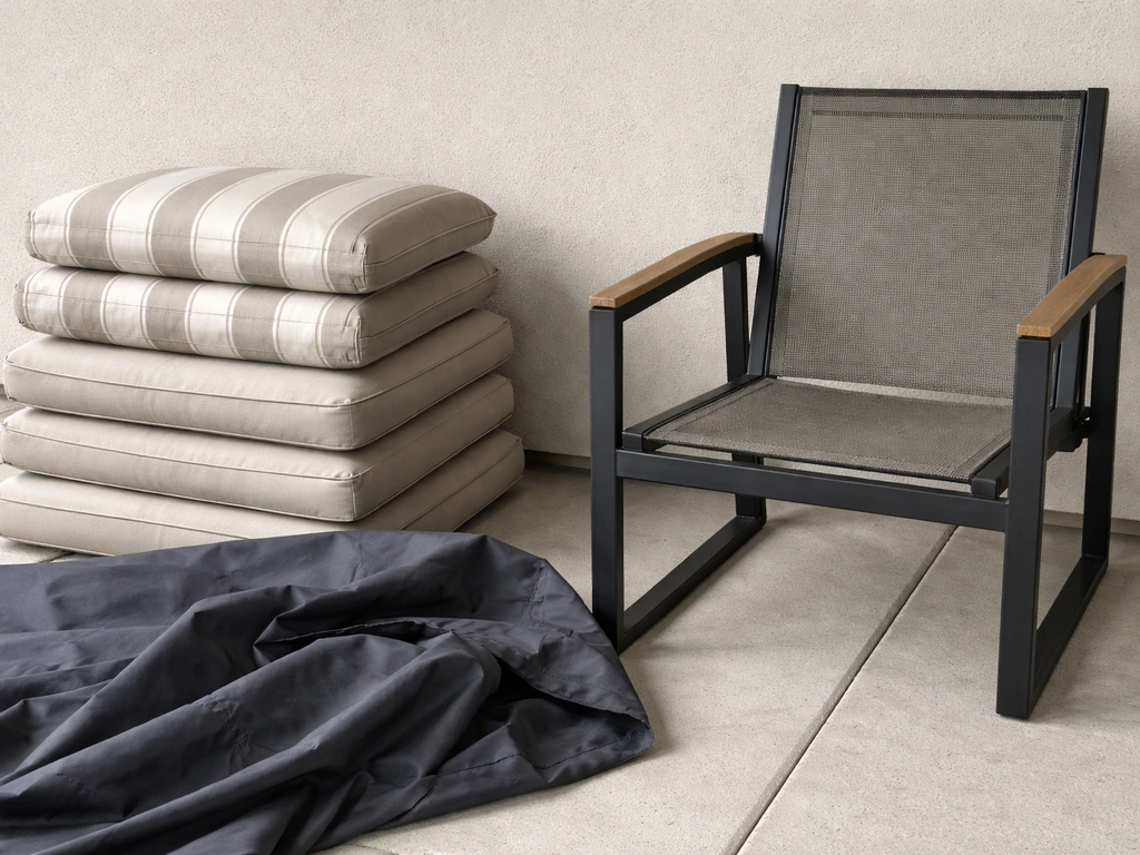 Clean dry cushions and chair frame prepared for off-season covering with a cover nearby.