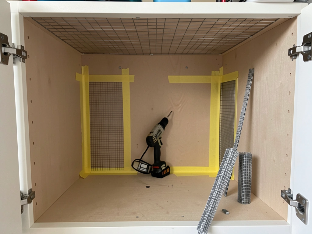 Painter’s tape layout marking which cabinet sides and top will be replaced with mesh for airflow