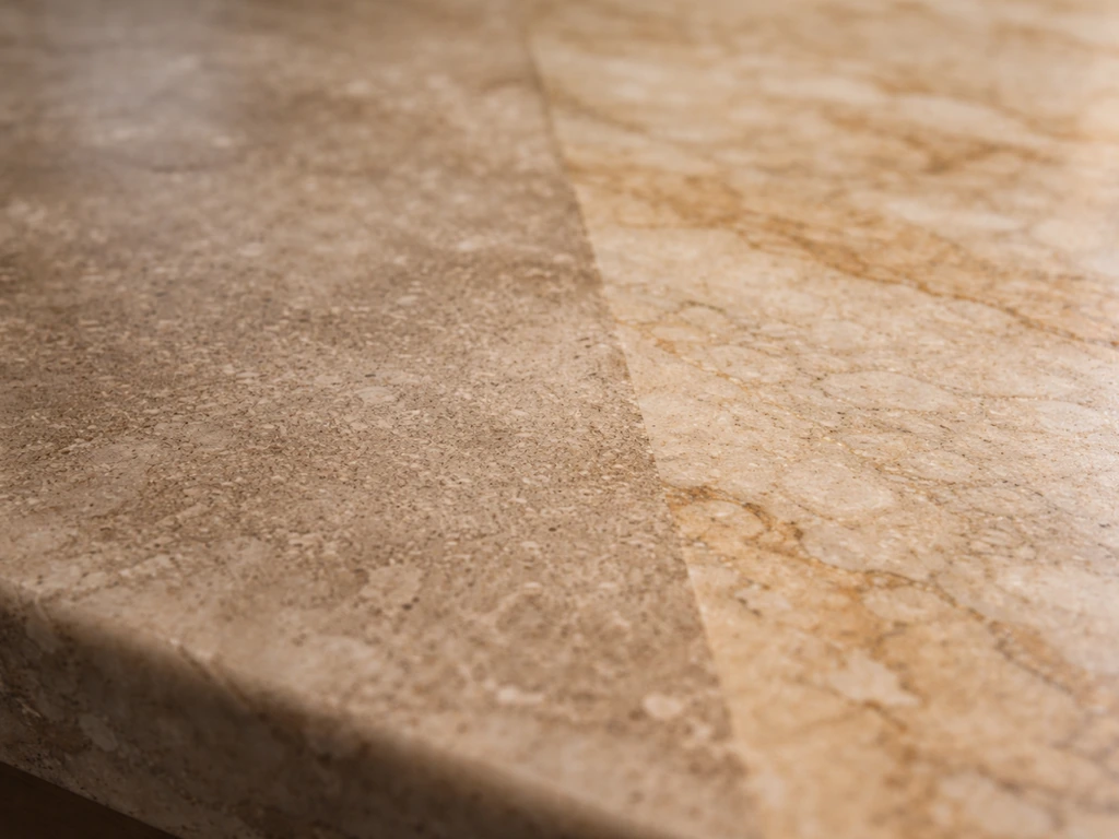 Close-up of etched sandstone/limestone next to a clean unetched section, showing acid damage texture.