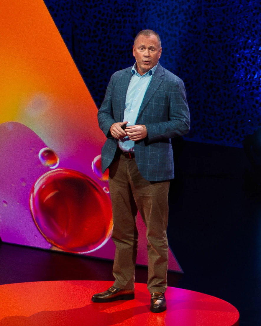 Nicolai Tangen speaking on stage at a conference