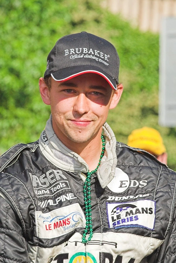 Nicolas Kiesa in racing gear and cap, posing outdoors