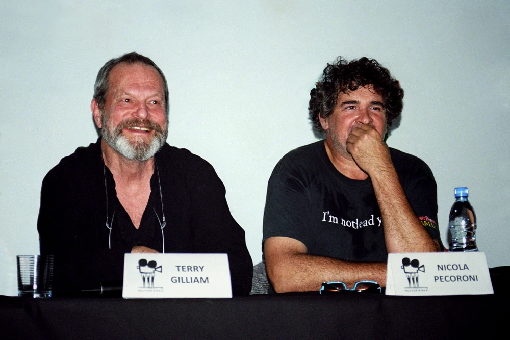 Nicola Pecorini seated at a panel beside Terry Gilliam, with a name placard identifying him as Nicola Pecorini.
