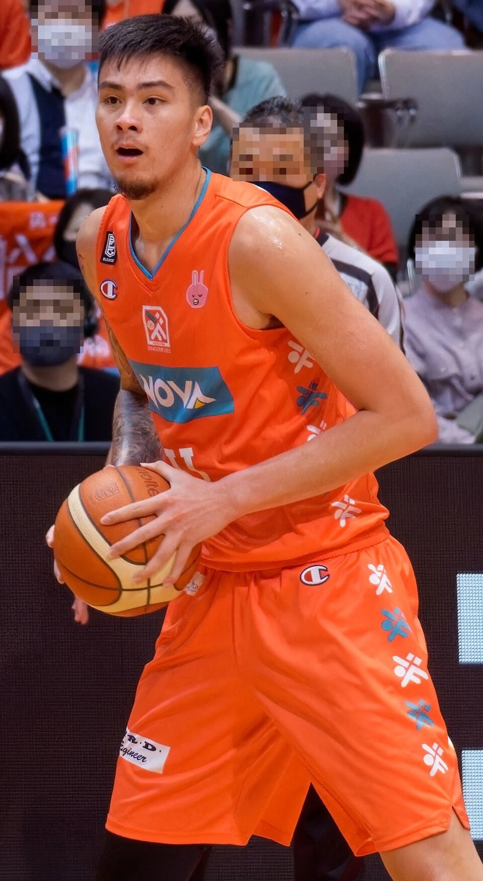 Kai Sotto in an orange basketball uniform holding a ball during a game