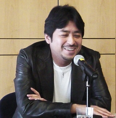 Kazuki Takahashi smiling at a microphone during a public appearance