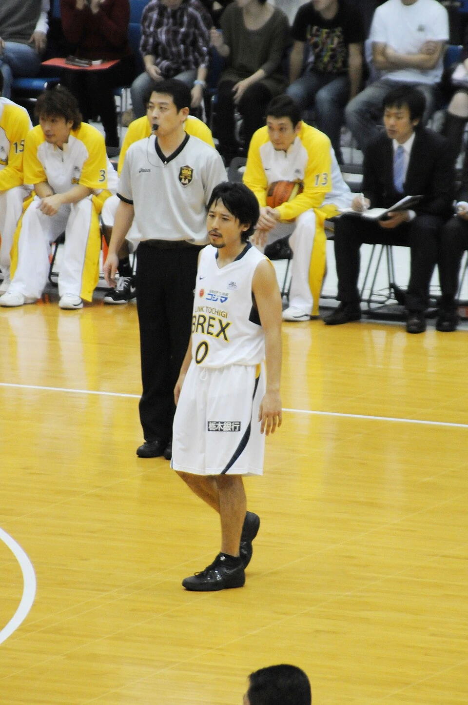 Yuta Tabuse standing on the basketball court in a white Link Tochigi Brex uniform