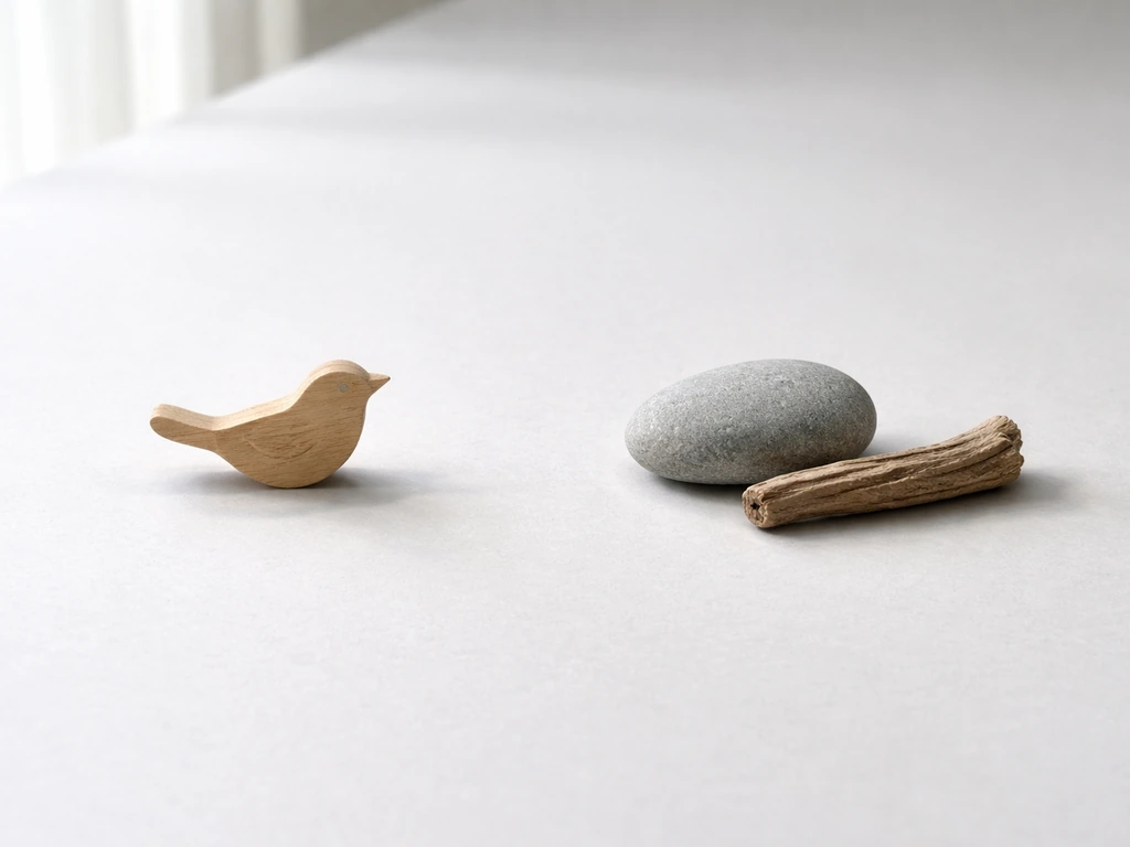 Minimal desk scene with two small symbolic tokens representing bird alarm and sea danger, for meaning disambiguation