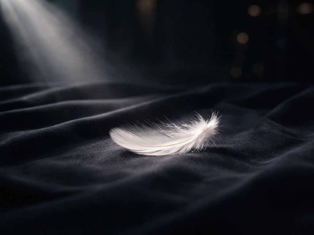 Moody close-up of a single feather on dark fabric, evoking the theme of a song called “A Bird Without Wings.”