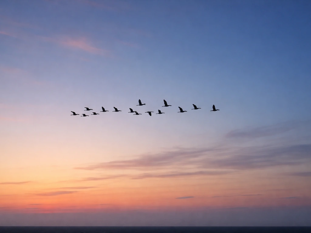 Silhouette flock of migrating birds over a horizon with changing dawn-to-dusk skies.