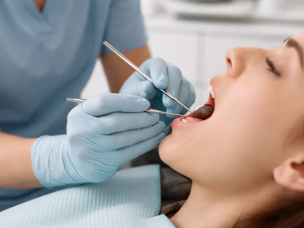 Dental clinician gently using a probe to examine a patient’s gumline in a bright clinic.
