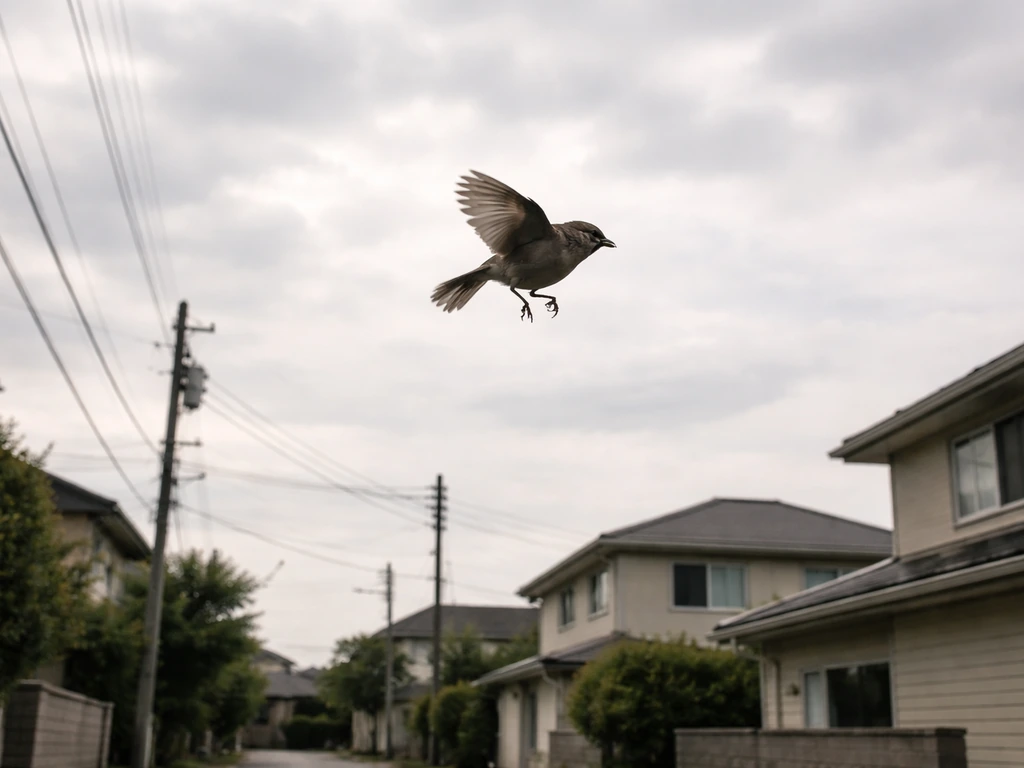 A small bird tumbling mid-fall over quiet homes under a cloudy sky.