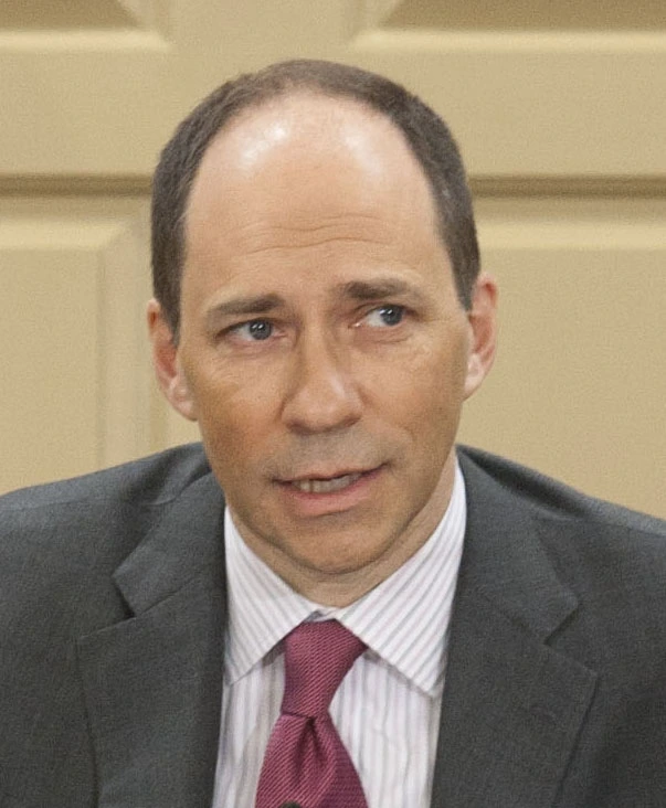 Portrait photo of Marcus W. Brauchli in a suit and tie