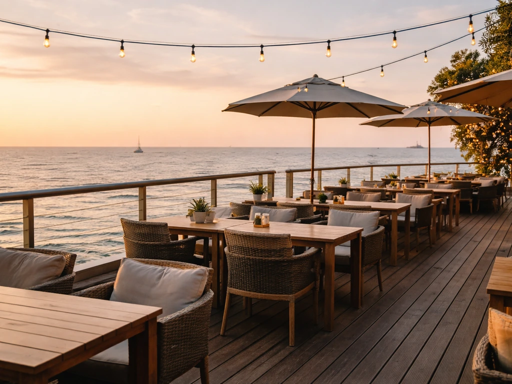 Golden-hour view of Patio 66 pier-side patio with ocean bay scenery and set outdoor seating