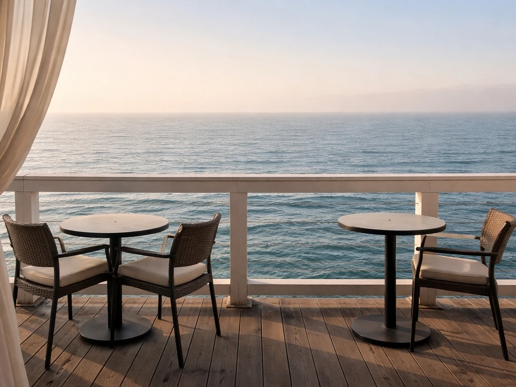 Ocean-side patio view from a pier with railings, horizon over Santa Monica Bay, and outdoor seating.