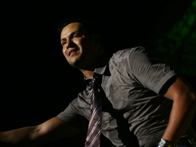 Víctor Manuelle performing on stage in a dimly lit concert photo