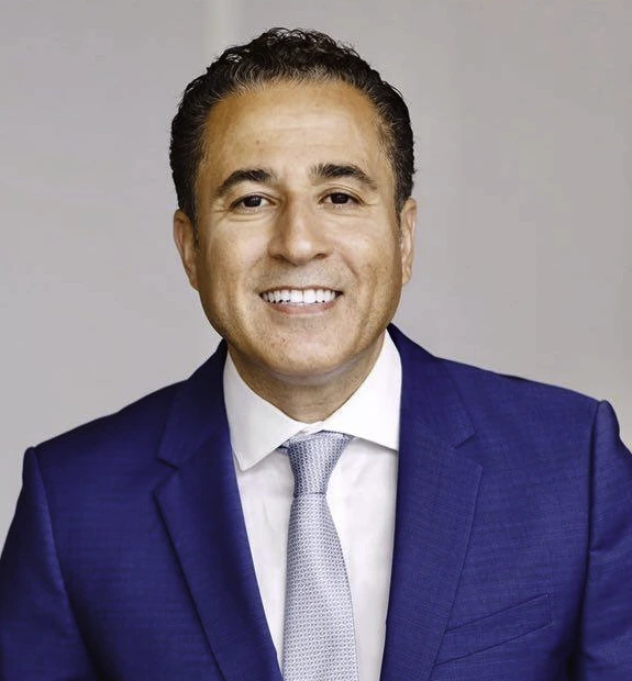 Victor Joseph Menezes in a formal portrait wearing a blue suit and tie.