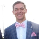 Portrait of Sterling Riggs smiling in a suit and bow tie
