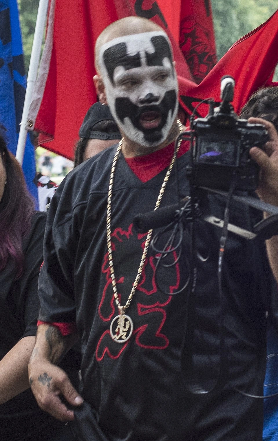 Shaggy 2 Dope performing live at a Juggalo March event, with face paint and stage attire.
