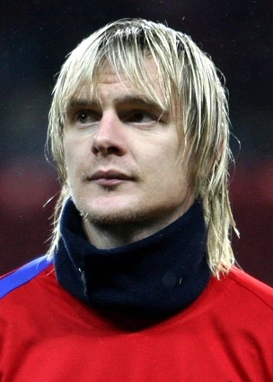 Miloš Krasić in a red football shirt during a match, portrait-style head-and-shoulders photo