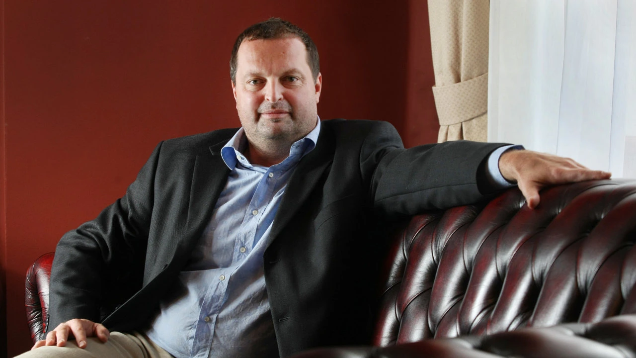 Radovan Vítek seated on a leather sofa in an editorial-style portrait