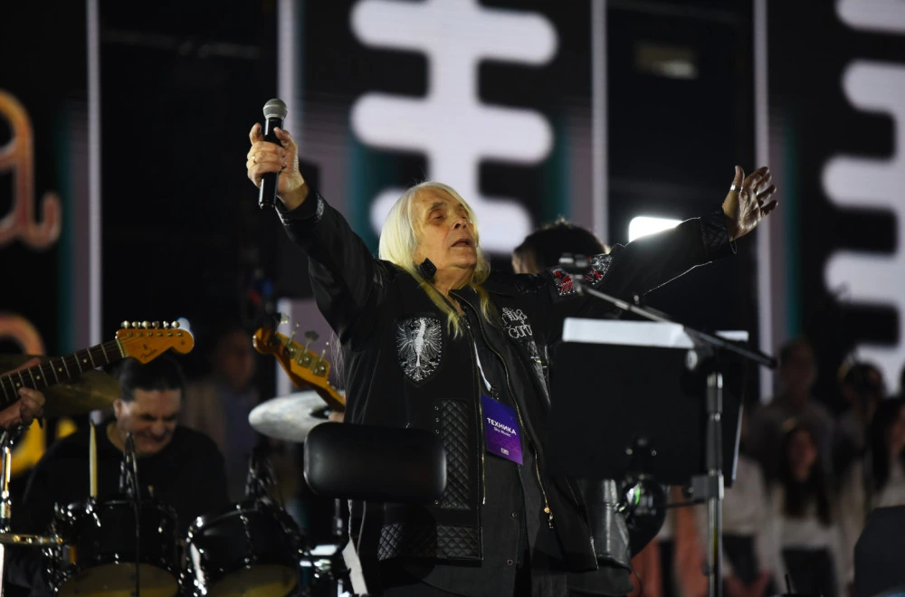 Bora Đorđević performing on stage with arms raised and holding a microphone