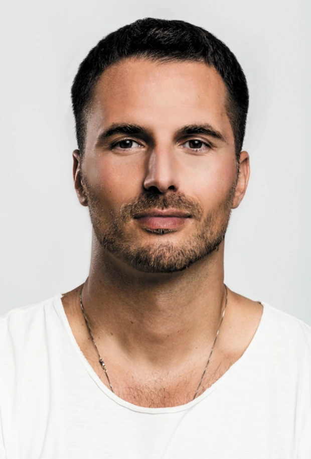 Portrait photo of a man against a plain light background