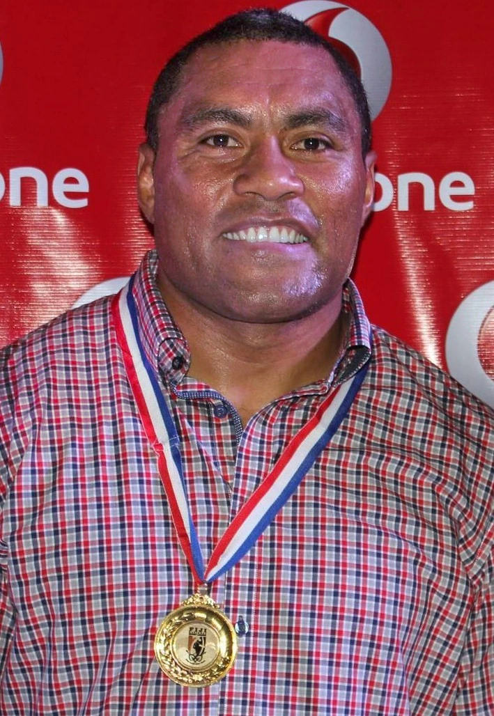 Petero Civoniceva posing with a medal in front of a Vodafone backdrop
